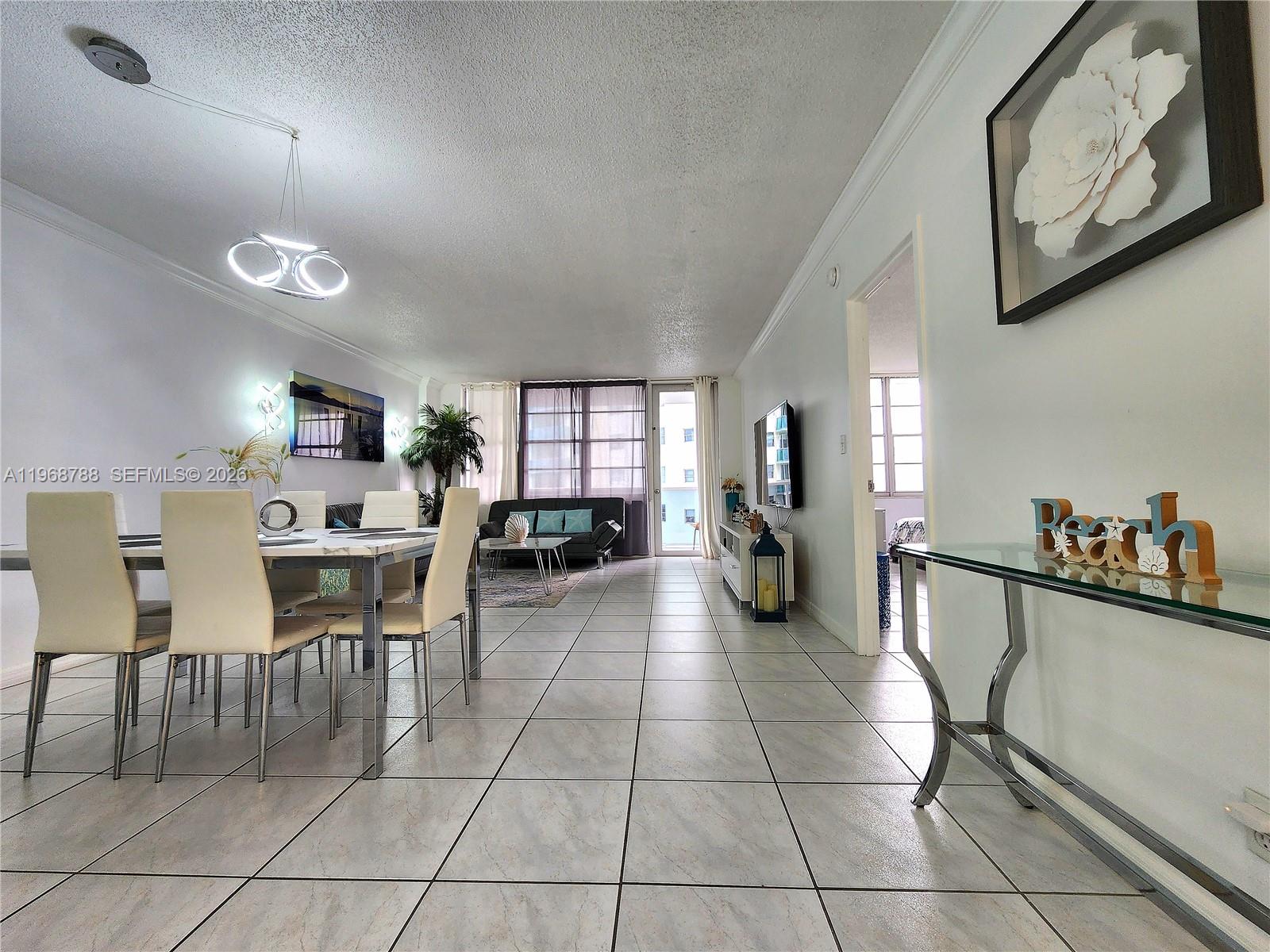 A dining area and living room feature white tile floors and modern light fixtures — 3725 S Ocean Dr # 620, Hollywood FL 33019, HOLLYWOOD, FL