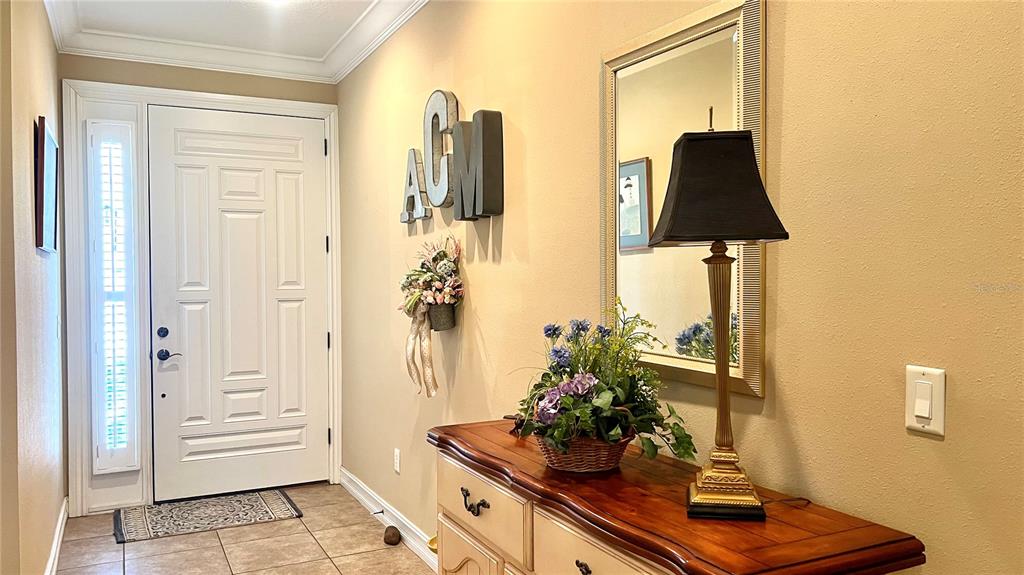 A two-story house with a beige stucco exterior, a two-car garage, and a paver driveway — 1266 RIBOLLA DRIVE, PALM HARBOR, FL