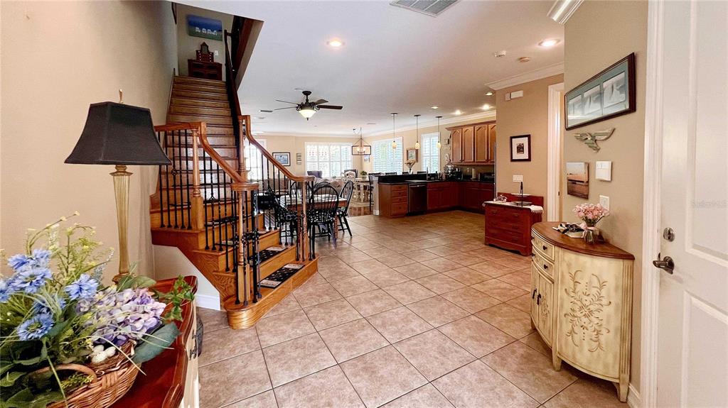 An entryway features a white door, a wooden console table, a lamp, and wall decor — 1266 RIBOLLA DRIVE, PALM HARBOR, FL