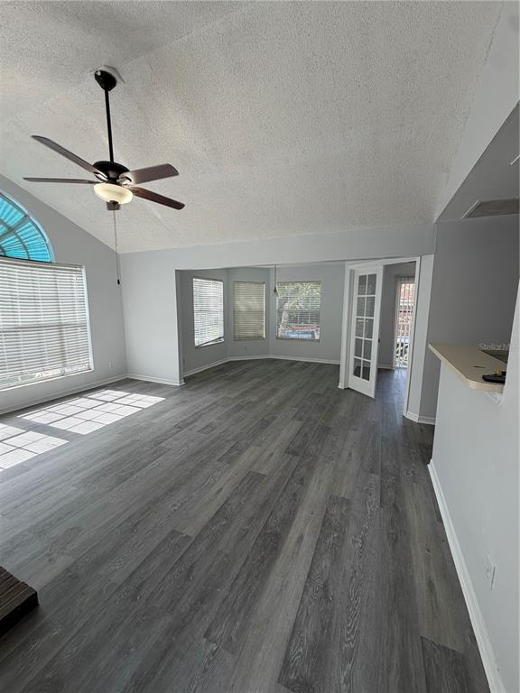 A living room with vaulted ceilings, gray wood-look flooring, and a ceiling fan — 645 STAFFORD TERRACE UNIT 156, ALTAMONTE SPRINGS, FL