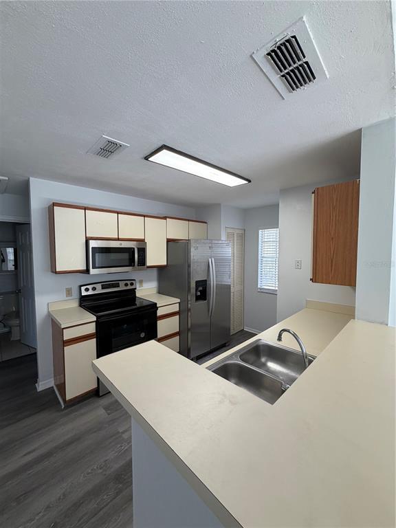A kitchen features light-colored cabinets, stainless steel appliances, and a double-basin sink — 645 STAFFORD TERRACE UNIT 156, ALTAMONTE SPRINGS, FL