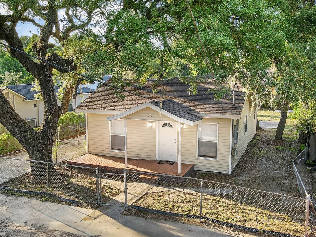 A single-story house with tan siding, a front porch, and a chain-link fence — 2116 E ELLICOTT STREET, TAMPA, FL