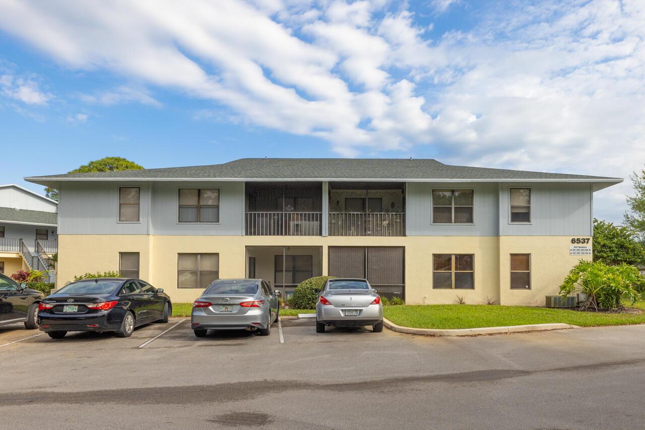 A two-story apartment building with a light-colored exterior and a parking lot in front — 6537 SE Federal Highway # 101, Stuart FL 34997, STUART, FL