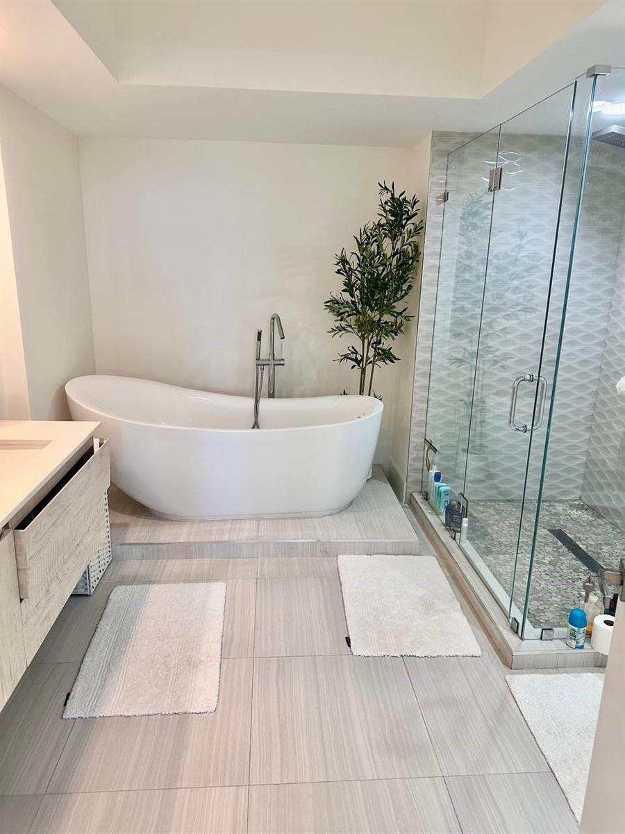 A bathroom features a freestanding tub on a raised platform next to a glass shower — 1830 S Ocean Drive # 2406, Hallandale Beach FL 33009, HALLANDALE BEACH, FL