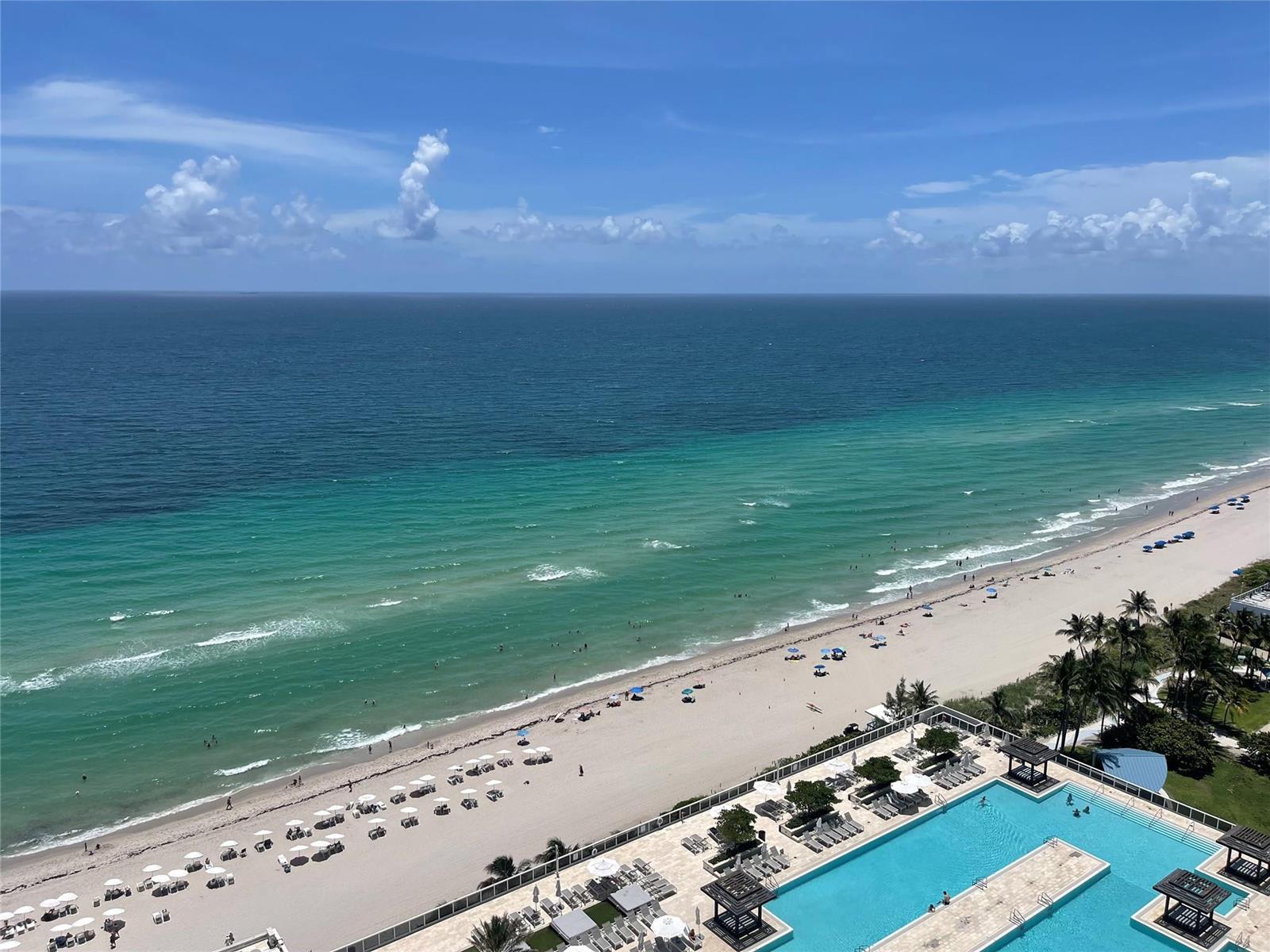 An elevated view of a beach, ocean, and a swimming pool deck at a resort — 1830 S Ocean Drive # 2406, Hallandale Beach FL 33009, HALLANDALE BEACH, FL