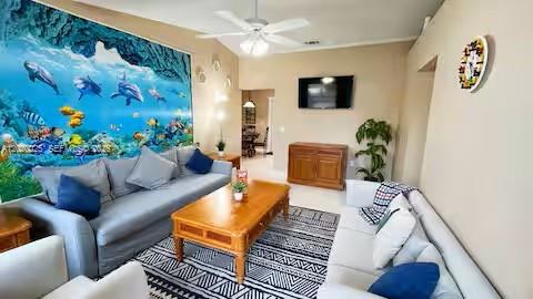 A living room features a large underwater-themed mural, two sofas, and a wooden coffee table — 404 Red Hawk Loop, Winter Haven FL 33880, WINTER HAVEN, FL