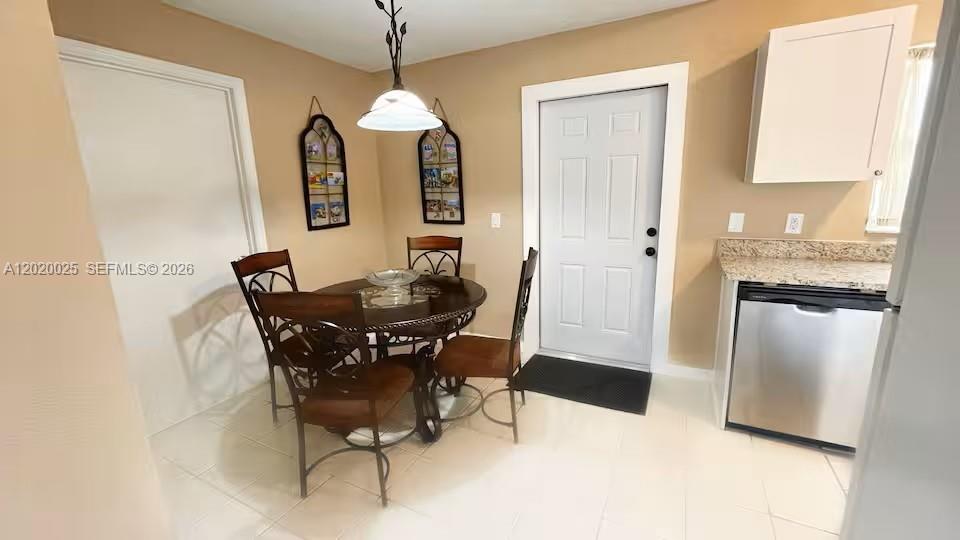 A dining area features a round table with four chairs, a pendant light, and tile flooring — 404 Red Hawk Loop, Winter Haven FL 33880, WINTER HAVEN, FL