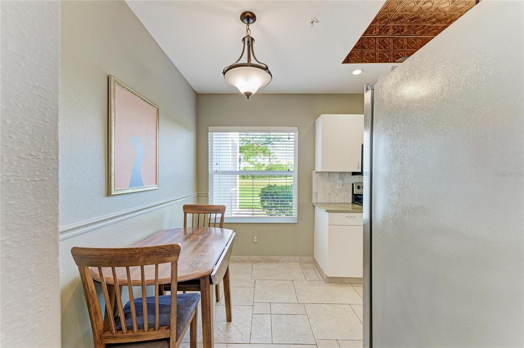 A dining area with a wooden table, chairs, tile flooring, and a view of outdoors — 9620 CLUB SOUTH CIRCLE UNIT 5108, SARASOTA, FL