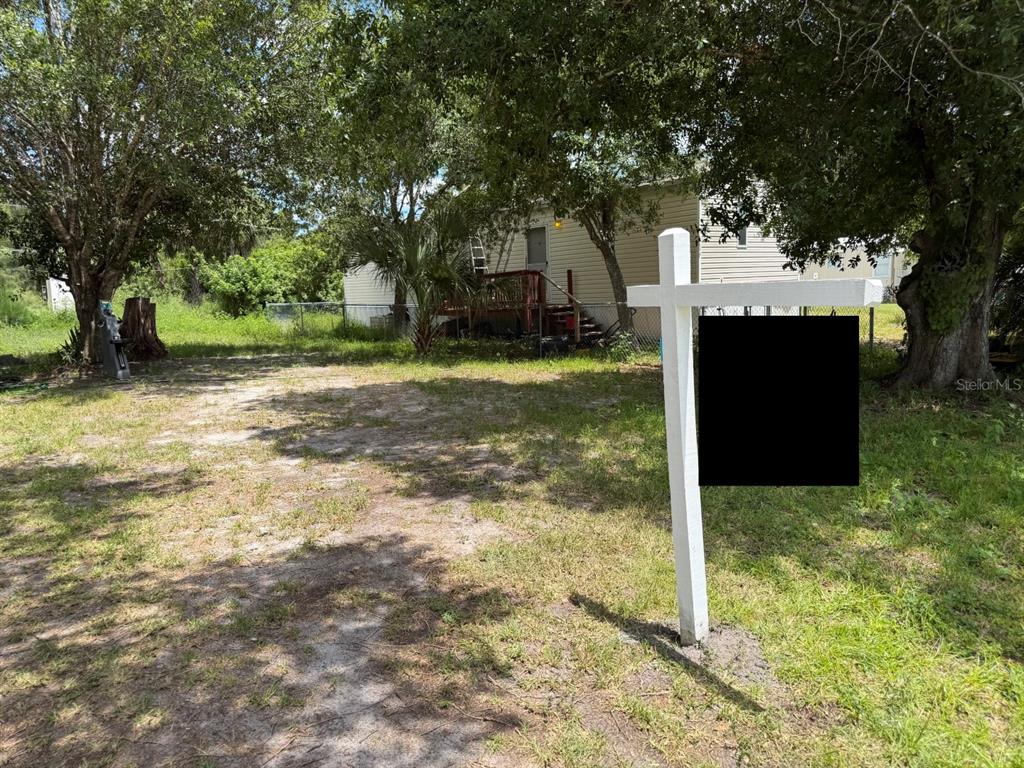 A real estate sign stands in the grassy yard in front of a single-story house — 5497 MAZE DRIVE, PUNTA GORDA, FL