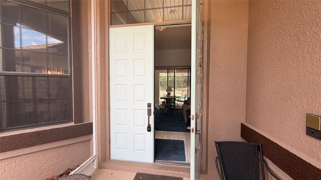 An open double front door reveals a view through the home to a backyard patio — 2496 E NEWHAVEN STREET, INVERNESS, FL