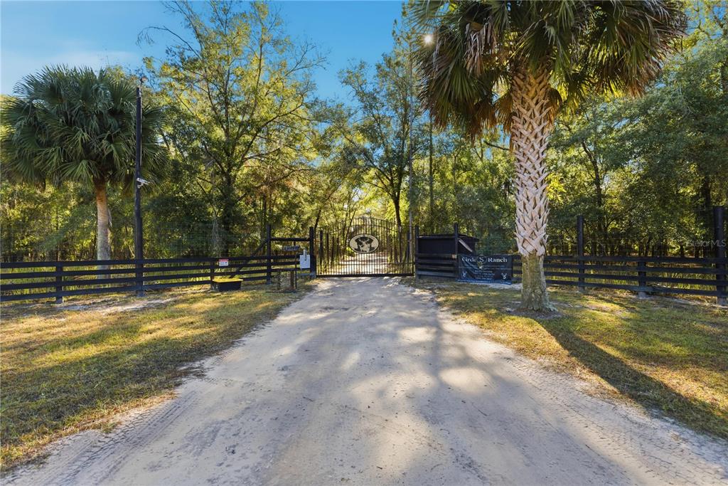 A dirt driveway leads to a gated entrance of a property named Circle S Ranch — TBD (Lot 2) NE 115TH LANE ROAD, FORT MC COY, FL