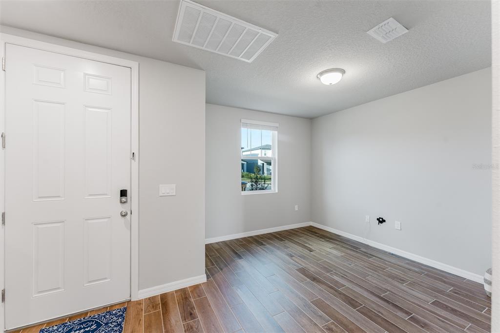 An entryway with a white door, light gray walls, and wood-look tile flooring — 5252 SANDERS OAK TRAIL, ST CLOUD, FL