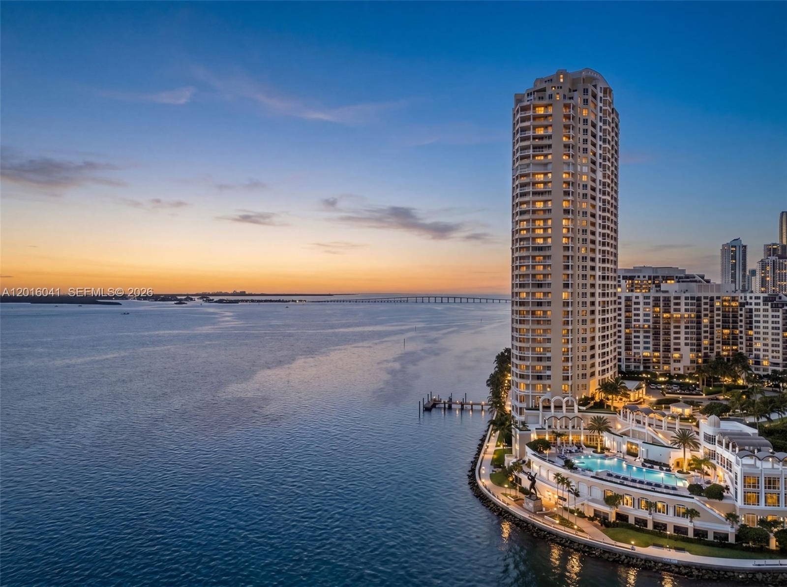 An aerial view shows a tall residential tower beside a pool deck and the ocean — 808 Brickell Key Dr # 3304, Miami FL 33131, MIAMI, FL
