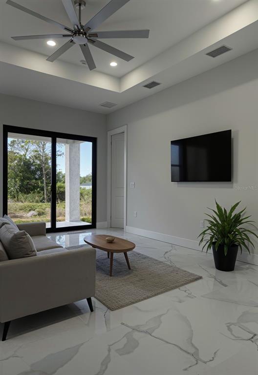A living room features a ceiling fan, marble-look tile floors, and a sliding glass door — 409 WESTERN AVENUE S, LEHIGH ACRES, FL