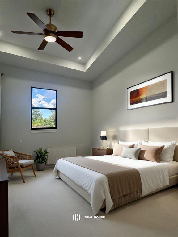 A bedroom features a tray ceiling, a ceiling fan, a bed, and a window — 409 WESTERN AVENUE S, LEHIGH ACRES, FL