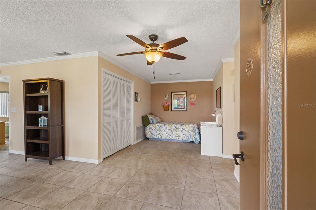 A room with tiled floors, a ceiling fan, a bookshelf, and a twin bed — 3836 LIGHTHOUSE WAY UNIT 3836, NEW PORT RICHEY, FL