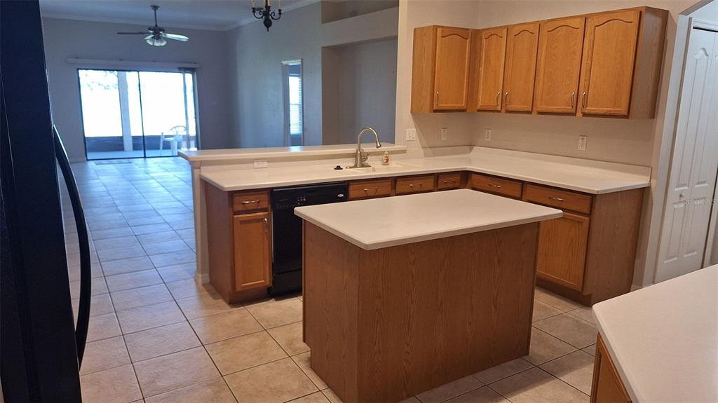 A kitchen with light wood cabinets, white countertops, a central island, and tile flooring — 1803 LAKE VILLA DRIVE, TAVARES, FL