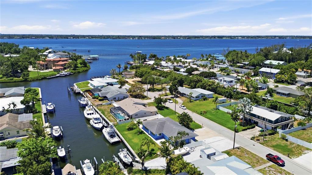 An aerial view shows waterfront homes with private boat docks along a canal — 908 24TH AVENUE W, PALMETTO, FL