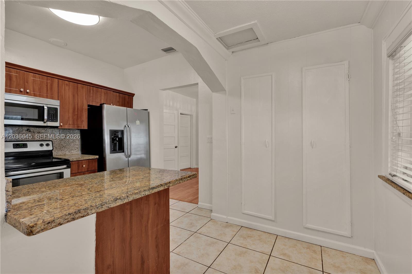 A kitchen features wood cabinets, granite countertops, stainless steel appliances, and tile flooring — 2145 SW 7th St # 1, Miami FL 33135, MIAMI, FL