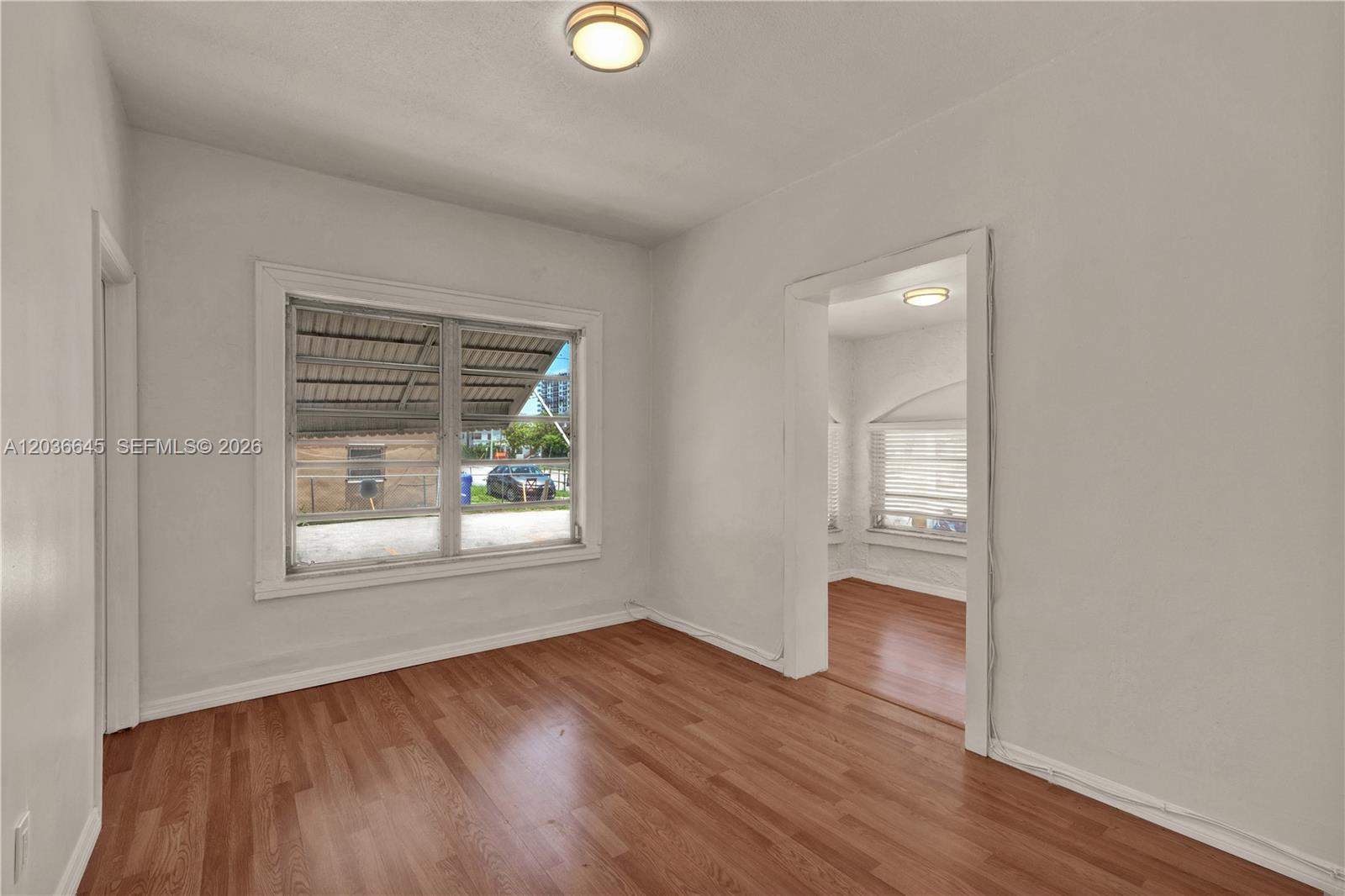 A room with hardwood floors and a window looks into an adjacent room — 2145 SW 7th St # 1, Miami FL 33135, MIAMI, FL