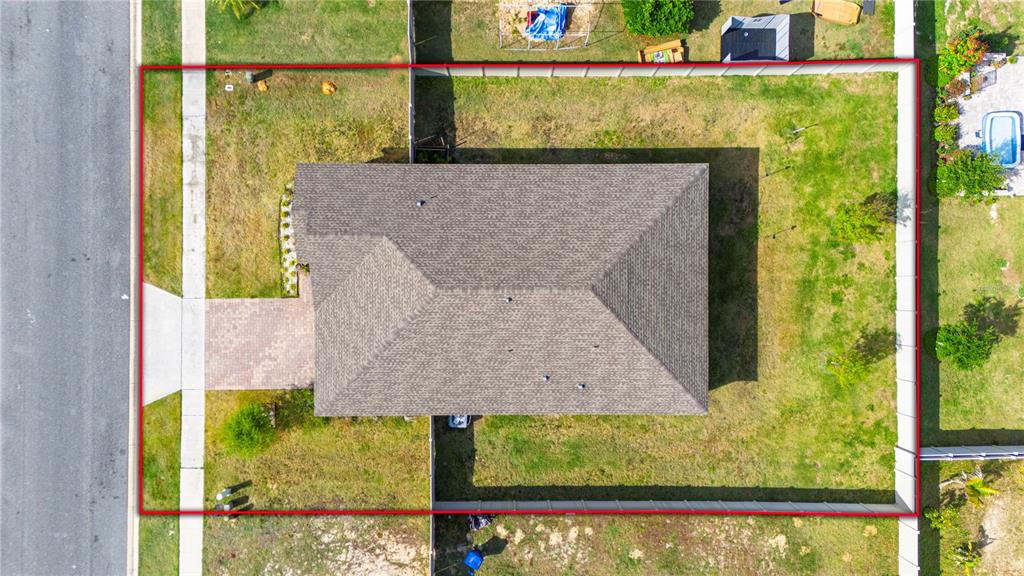 An aerial view shows a single-story house with a shingled roof on a fenced lot — 245 MESSINA PLACE, HOWEY IN THE HILLS, FL