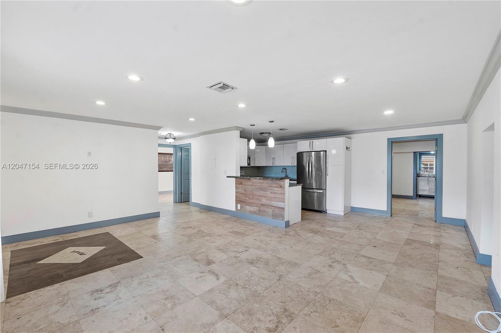 An open-concept living area features tile flooring, a kitchen with a breakfast bar, and recessed lighting — 1541 SW 52nd Ave, Plantation FL 33317, PLANTATION, FL