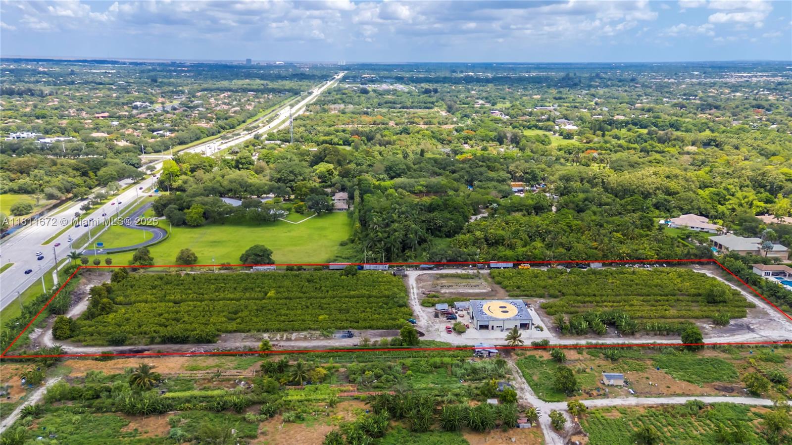 An aerial view shows a rectangular lot with a warehouse featuring a smiley face roof — 4077 SW 121st Ter, Davie FL 33330, DAVIE, FL