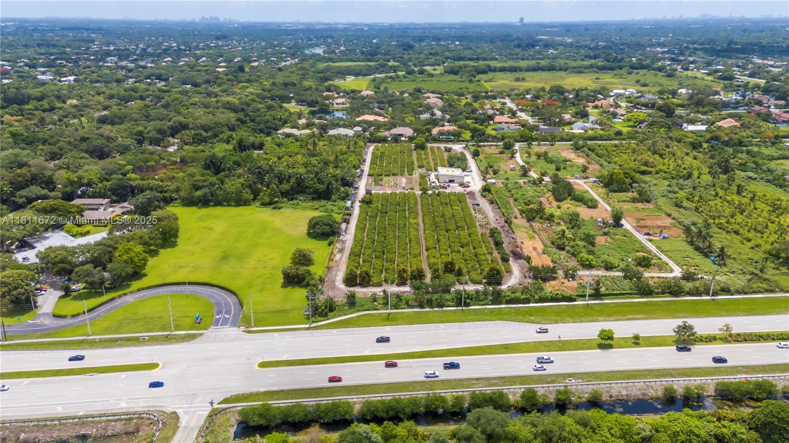 An aerial view shows a rectangular orchard property situated next to a multi-lane highway — 4077 SW 121st Ter, Davie FL 33330, DAVIE, FL