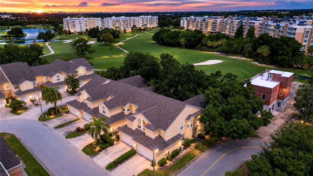 An aerial view shows a multi-unit residential building next to a golf course at sunset — 1050 STARKEY ROAD UNIT 2105, LARGO, FL