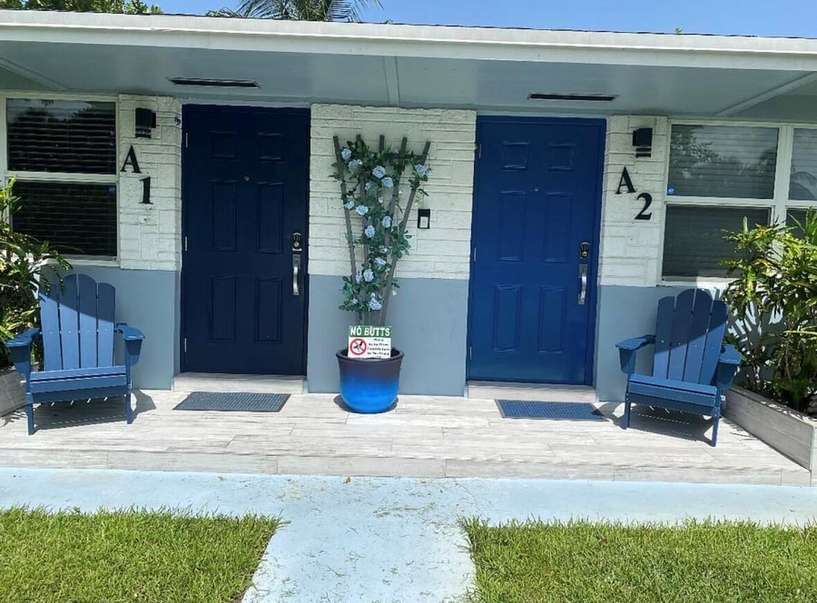Two blue front doors labeled A1 and A2 feature matching chairs and a potted plant — 136 Akron Street # B2, FL 33461, FL