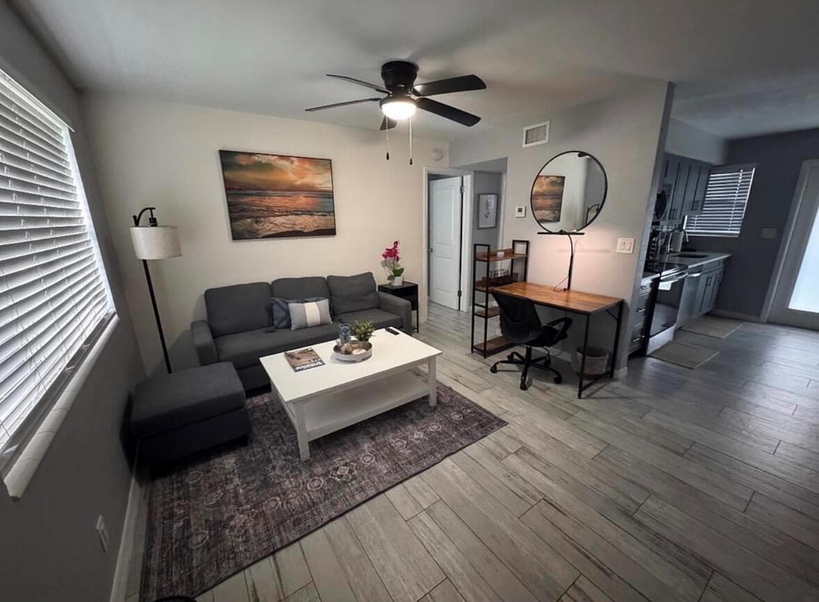 A living room features a grey sofa, white coffee table, desk, and wood-look tile flooring — 136 Akron Street # B2, FL 33461, FL