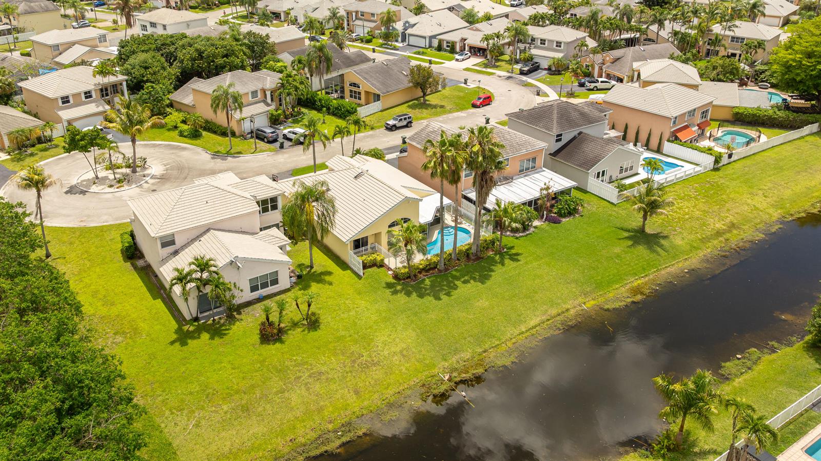 An aerial view shows suburban houses with swimming pools and a canal in Florida — 5535 NW 54th Circle, Coconut Creek FL 33073, COCONUT CREEK, FL