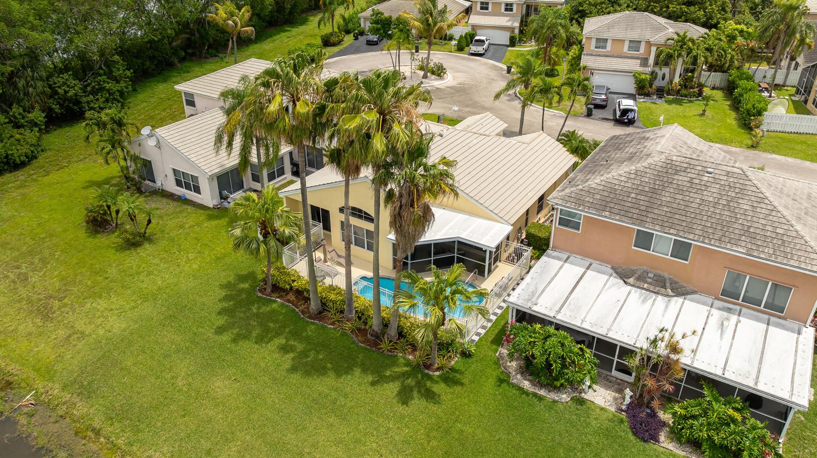 An aerial view shows a yellow house with a pool and palm trees — 5535 NW 54th Circle, Coconut Creek FL 33073, COCONUT CREEK, FL