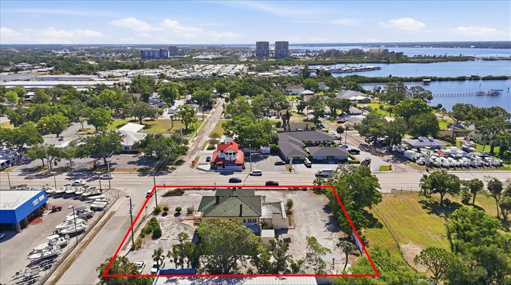 An aerial view shows a house with a green roof on a large, paved lot — 337 8TH AVENUE W, PALMETTO, FL