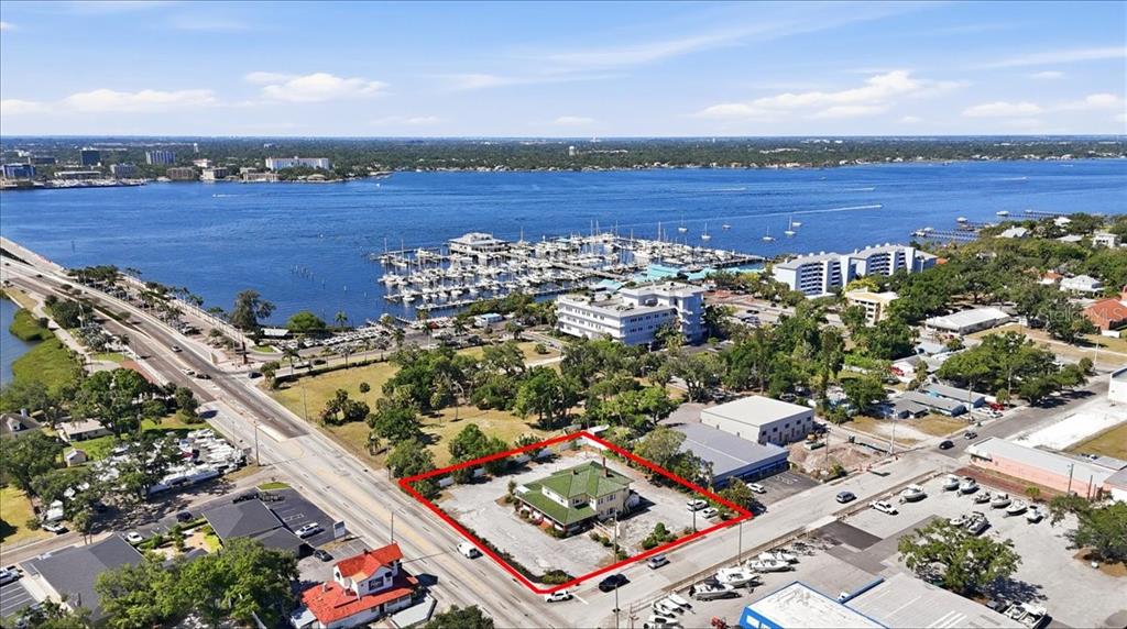 An aerial view shows a house with a green roof outlined in red near a marina — 337 8TH AVENUE W, PALMETTO, FL