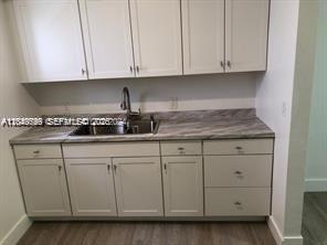 A kitchen features light-colored cabinets, a stainless steel sink, and a marble-patterned countertop — 30 S Shore Dr # 6, Miami Beach FL 33141, MIAMI BEACH, FL