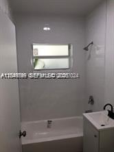 A bathroom features a white bathtub, a pedestal sink, and a window above the tub — 30 S Shore Dr # 6, Miami Beach FL 33141, MIAMI BEACH, FL