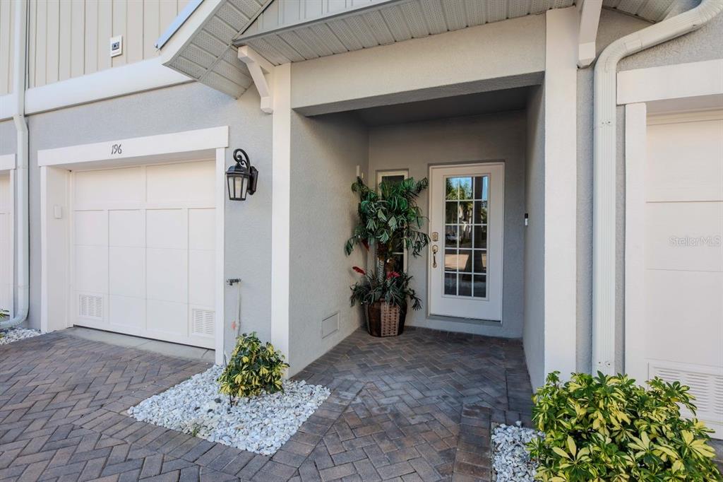 The exterior of a home features a garage, a paved walkway, and a front entryway — 196 HAVEN BEACH DRIVE, INDIAN ROCKS BEACH, FL