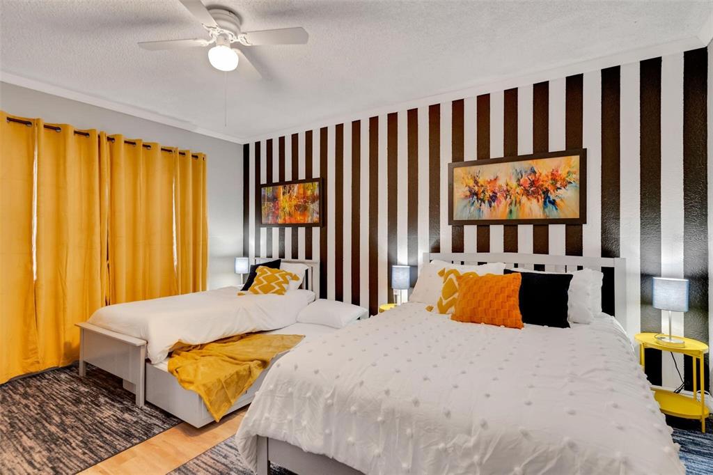 A bedroom features two beds, a black and white striped wall, and yellow curtains — 3357 TIMBERLINE ROAD W, WINTER HAVEN, FL