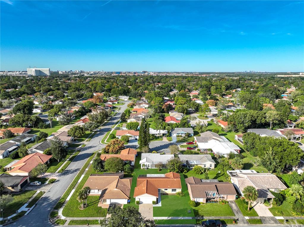 An aerial view shows a suburban neighborhood with single-family homes, paved streets, and mature trees — 5321 WILLIAMSPORT DRIVE, ORLANDO, FL