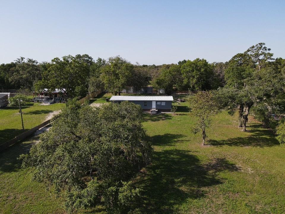An aerial view shows a single-story house situated on a large, tree-filled grassy lot — 17524 MEDLEY AVENUE, SPRING HILL, FL