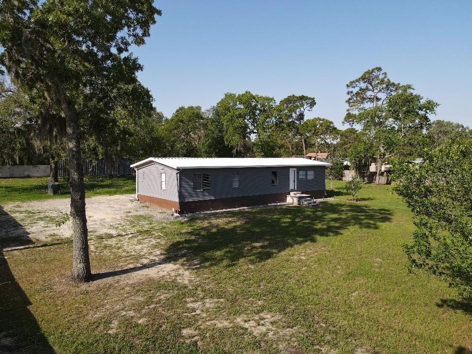 An aerial view of a gray manufactured home with a white roof on a grassy lot — 17524 MEDLEY AVENUE, SPRING HILL, FL