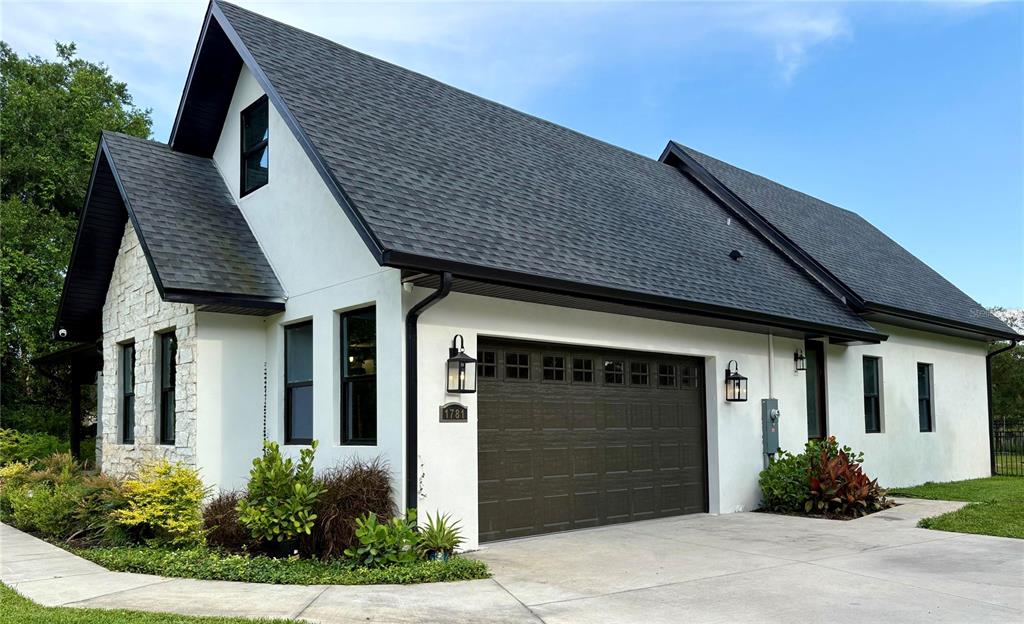 A white house with stone accents, a dark roof, and a two-car garage — 1781 TAYLOR ROAD, PORT ORANGE, FL