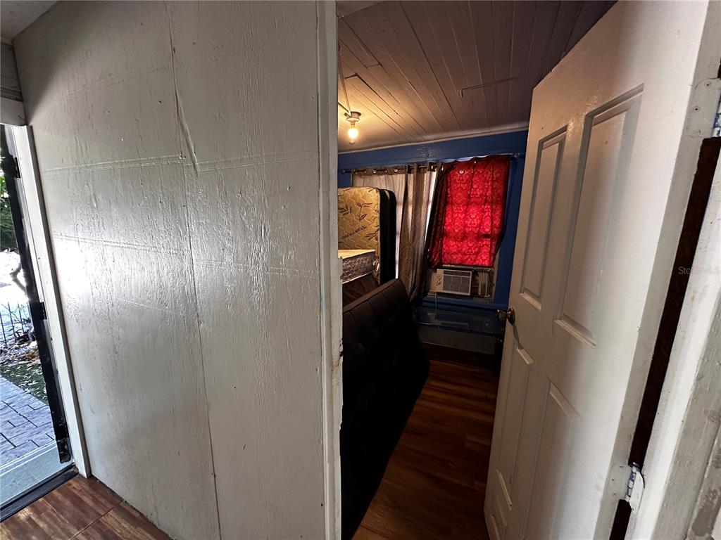 A view through a doorway into a room with wood-look flooring and a window — 2415 MARCONI STREET, TAMPA, FL