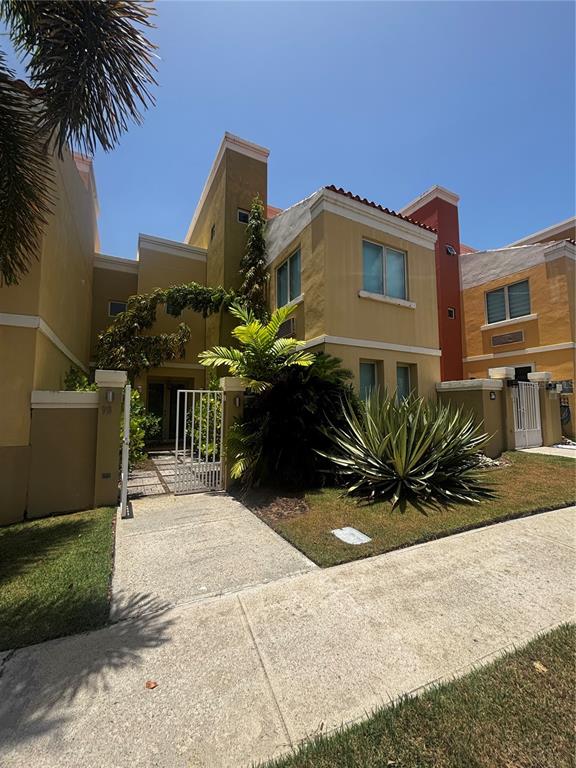 A two-story yellow stucco townhouse with a gated entryway and a large agave plant — 98 VIA POSITANO UNIT 98, HUMACAO, PR