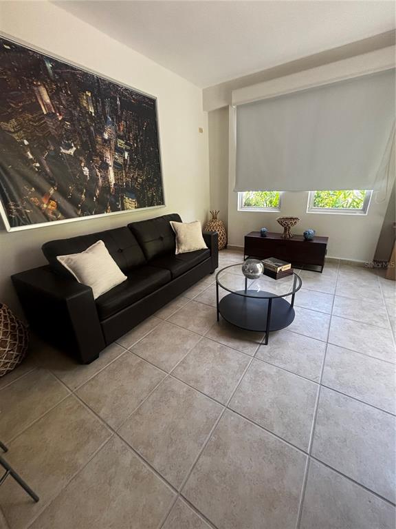 A living room features a black sofa, a round glass coffee table, and tile flooring — 98 VIA POSITANO UNIT 98, HUMACAO, PR