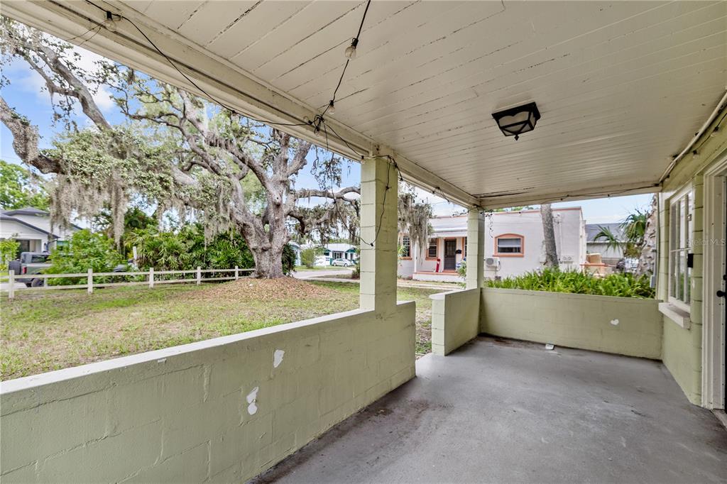 A covered concrete porch with light green block walls and a beadboard ceiling — 5914 N OLA AVENUE, TAMPA, FL