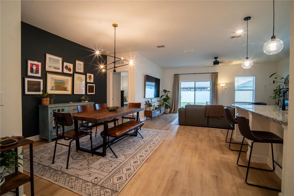 A living room features light wood-look flooring, a corner sectional sofa, and sliding glass doors — 5859 HERDER ROAD, ST CLOUD, FL