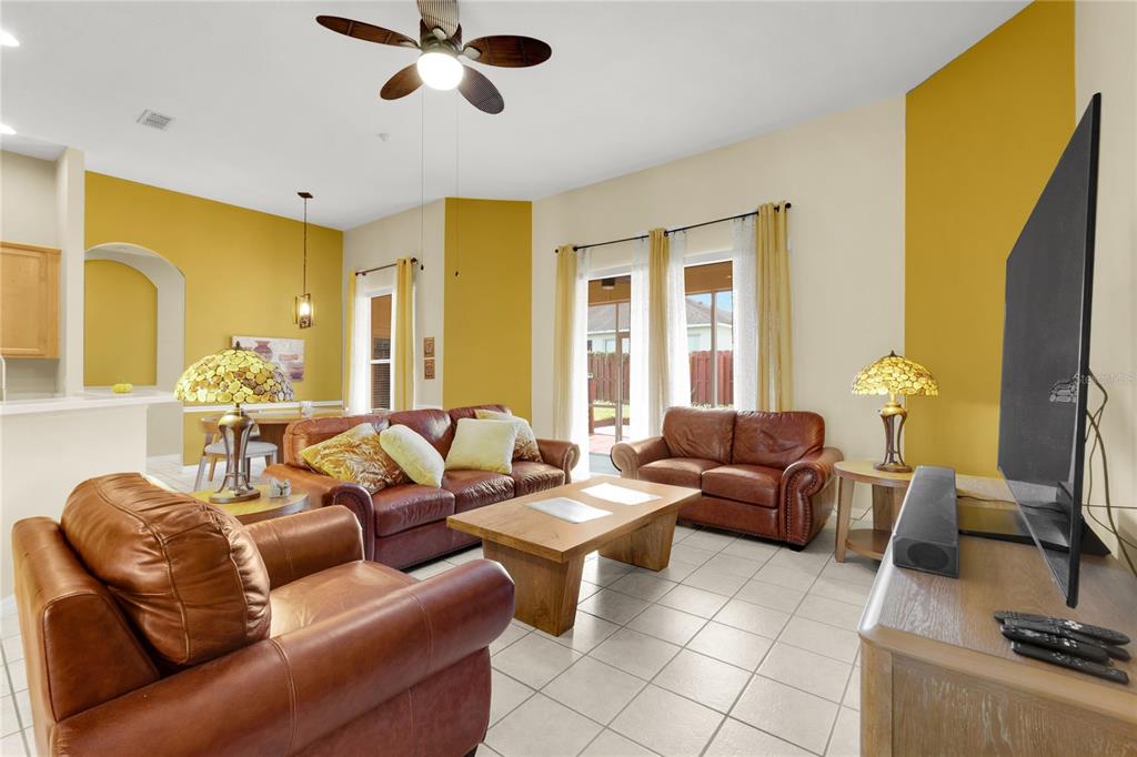 A living room features leather furniture, a wooden coffee table, and yellow accent walls — 730 BRIDGEWAY BLVD, ORLANDO, FL