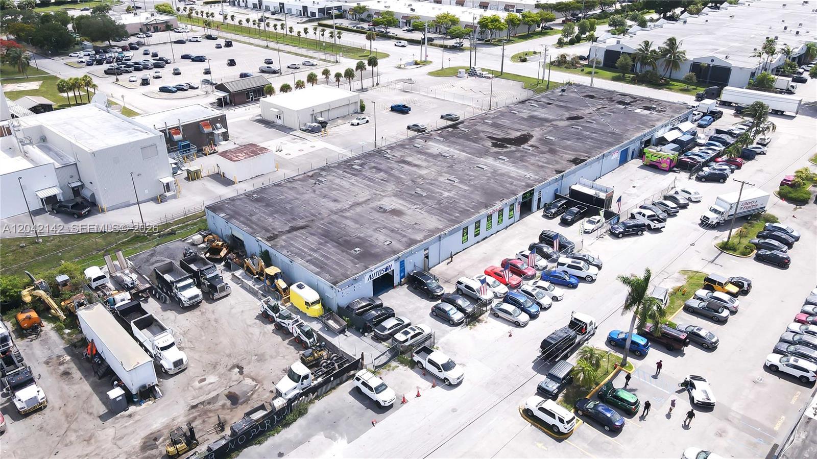 An aerial view shows a commercial building with a large parking lot and heavy machinery — 5500 NW 74th Ave, Miami FL 33166, MIAMI, FL